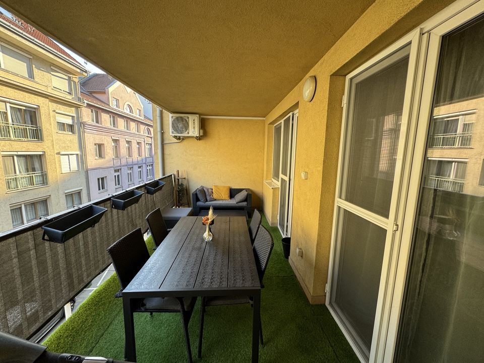 A loggia korábban: műfű, sötét asztal és székek
